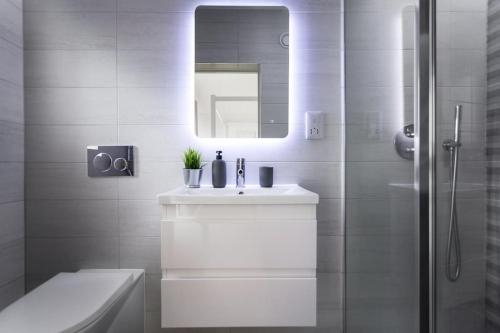 a white bathroom with a sink and a mirror at Luxury 3 floor Town House by Tolcarne Beach in Newquay