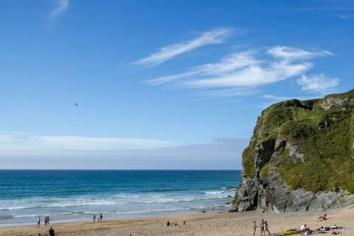 a group of people on a beach near the ocean at Luxury 3 floor Town House by Tolcarne Beach in Newquay