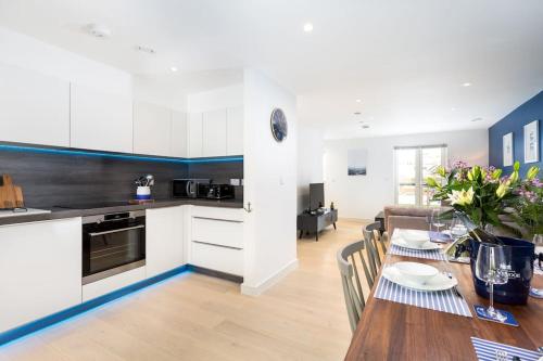 a kitchen and dining room with a table and a kitchen and a living room at Luxury 3 floor Town House by Tolcarne Beach in Newquay
