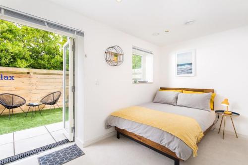 a bedroom with a bed and a sliding glass door at Luxury 3 floor Town House by Tolcarne Beach in Newquay
