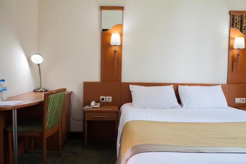 a hotel room with a bed and a desk and a bed at Gorillas City Centre Hotel in Kigali