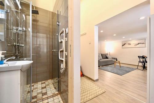 ein Bad mit einer Dusche und einem Waschbecken in einem Zimmer in der Unterkunft Cute Gallery Flat in Király Street in Budapest