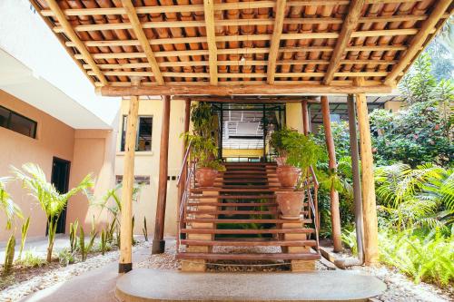 a stairway leading to a house with a wooden pergola at Gorillas City Centre Hotel in Kigali