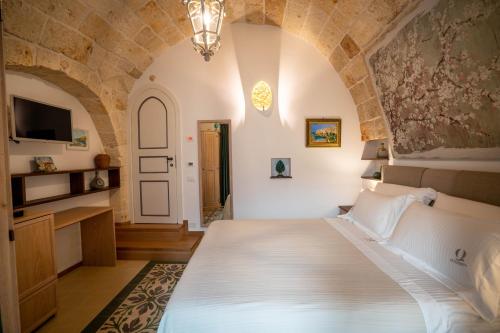 a bedroom with a large white bed in a room at Quintessenza Luxury Domus in Polignano a Mare