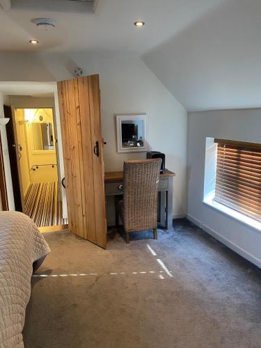 a bedroom with a bed and a desk and a door at B&Bat no3 in Market Bosworth