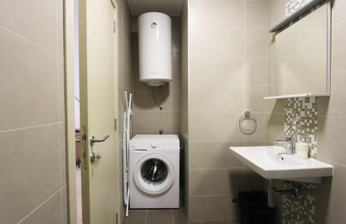 a small bathroom with a washing machine and a sink at Lavender Bay Apartment in Donji Morinj