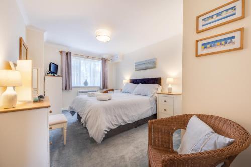 a bedroom with a bed and a chair at Clover Cottage in Begelly