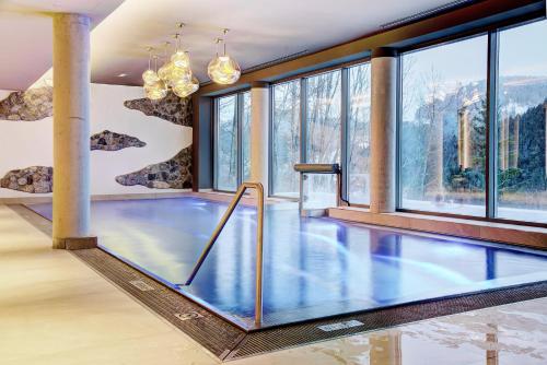 una piscina en una habitación con ventanas en Königswieser Hof, en Königswiesen