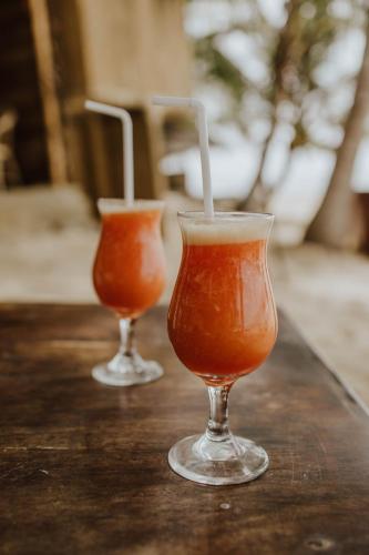 two drinks in glasses sitting on a table at The Alpha Monkey hotel & Tree house in Tangalle