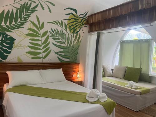 a bedroom with two beds and a window with plants on the wall at ROYAL SUITES - PORT BARTON in San Vicente