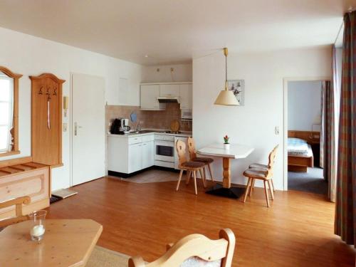 een keuken en een woonkamer met een tafel en stoelen bij Skipper Appartements in Niendorf