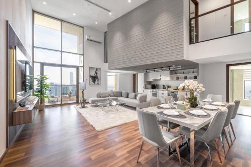 a dining room and living room with a table and chairs at Ultra Luxury JBR Duplex Penthouse - Free 5 star beach access in Dubai