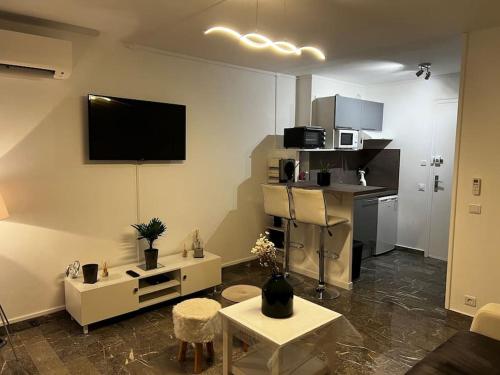 salon z telewizorem na ścianie w obiekcie Chez Julien & Ornella w mieście Saint-Laurent-du-Var
