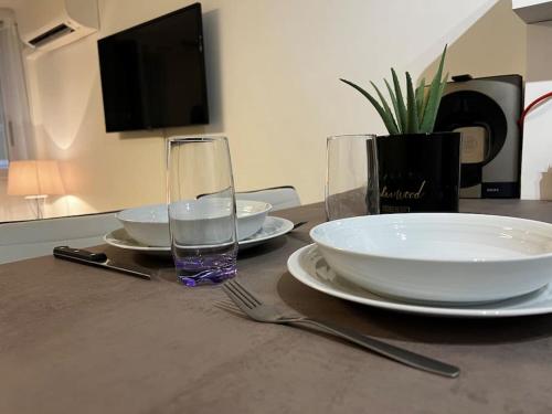 a table with plates and a glass of water on it at Chez Julien & Ornella in Saint-Laurent-du-Var