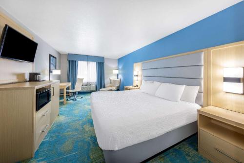 a large hotel room with a bed and a television at Days Inn by Wyndham Springville in Springville