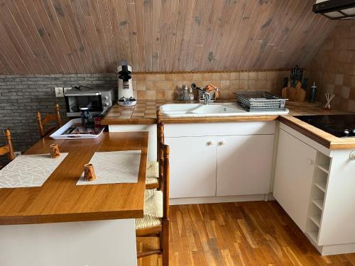 une cuisine avec un évier et un plan de travail en bois dans l'établissement LE RAYON DE SOLEIL, à Froberville