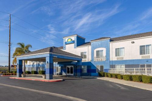 un gran edificio azul y blanco con aparcamiento en Days Inn by Wyndham Lathrop, en Lathrop