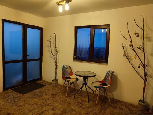 a room with two chairs and a table and two windows at Cabana La Cassian in Vulcan