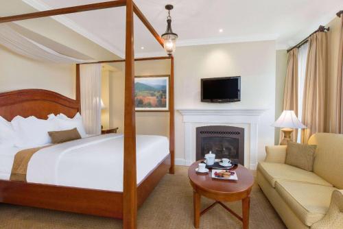 um quarto de hotel com uma cama e uma lareira em The George Washington - A Wyndham Grand Hotel em Winchester