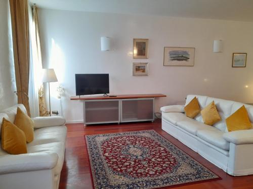 a living room with two white couches and a television at San Marco2 Apartment in Venice