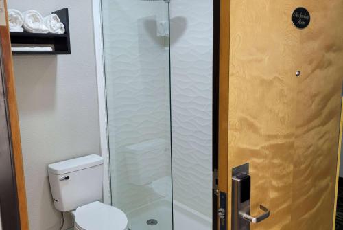 a bathroom with a toilet and a glass shower at Days Inn by Wyndham Childress in Childress