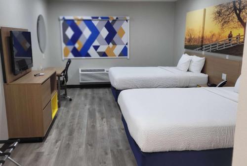 a hotel room with two beds and a flat screen tv at Days Inn by Wyndham Childress in Childress