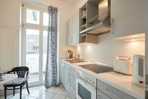 eine Küche mit einem Waschbecken, einem Tisch und einem Fenster in der Unterkunft Villa Cremona Ferienwohnung 4 in Bansin