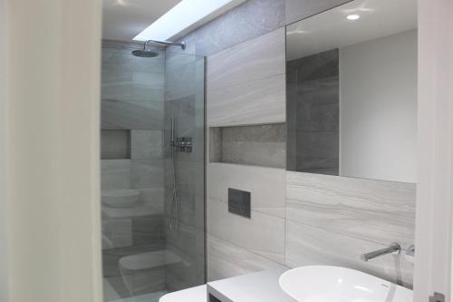 a bathroom with a sink and a glass shower at Quinta Milhão - Casa do Pomar in Guimarães