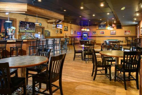 a restaurant with tables and chairs and a bar at Quality Inn in Lewisburg