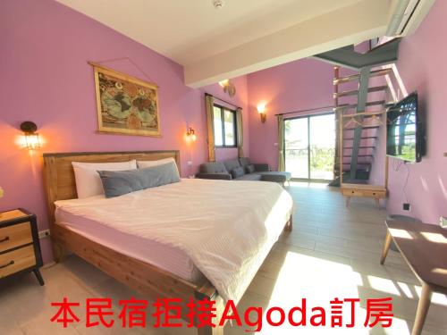 a bedroom with a bed in a room with purple walls at Starry Night in Taitung City