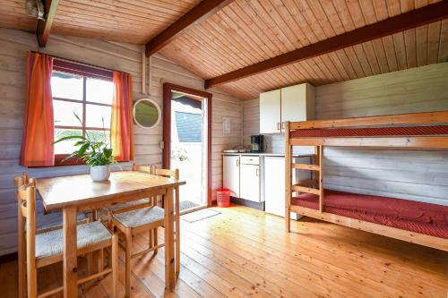 Zimmer mit einem Tisch und einem Etagenbett in der Unterkunft First Camp Skovlund Camping & Cottages in Båring