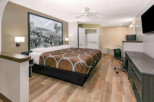 a hotel room with a bed and a desk at Super 8 by Wyndham Moss Point in Moss Point