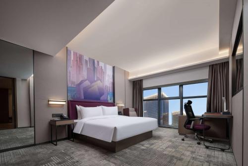 a hotel room with a bed and a desk and a window at Days Hotel by Wyndham Chongqing Chenjiaping in Chongqing
