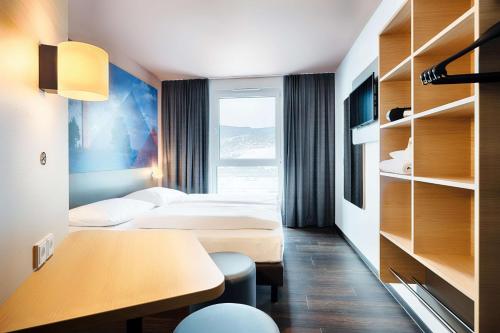 a hotel room with two beds and a desk at B&B Hotel Willingen in Willingen