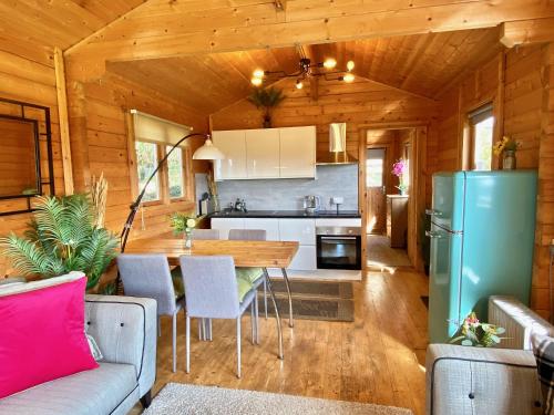 a kitchen and living room of a log cabin at Yealm Cabin Self Catering Log Cabin in Devon with Hot Tub in Plymouth