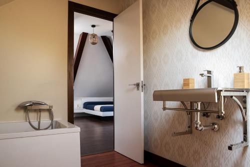 baño con lavabo, espejo y cama en Apartamentos Redondela - A Casa da Praia, en Redondela