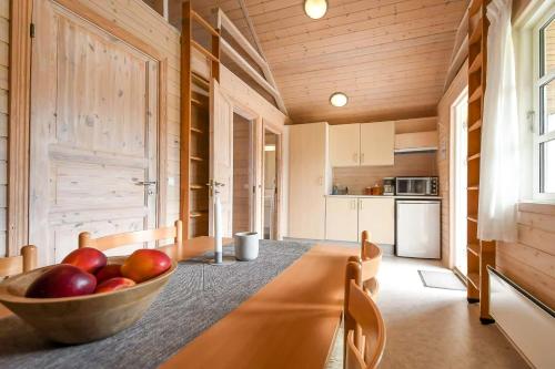 eine Küche mit einer Schale Äpfel auf dem Tisch in der Unterkunft First Camp Skovlund Camping & Cottages in Båring