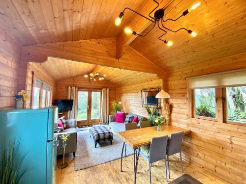 a dining room and living room in a log cabin at Yealm Cabin Self Catering Log Cabin in Devon with Hot Tub in Plymouth