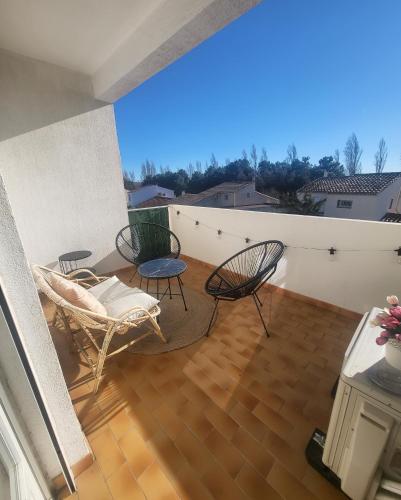 a patio with two chairs and a table on a balcony at Marina 4 ou 8 ou 9 in Narbonne