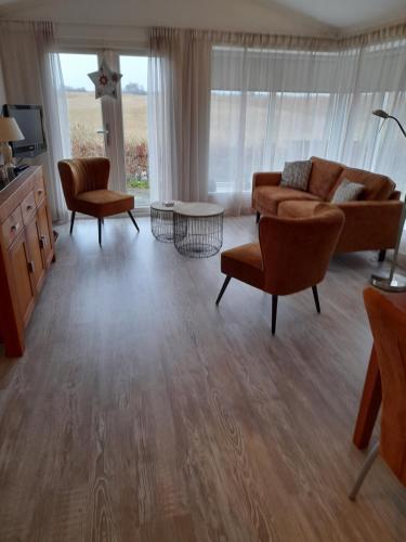 uma sala de estar com um sofá e cadeiras em Wuivend Riet gelegen op Resort Venetie em Giethoorn