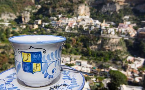 a coffee cup sitting on a plate with a view of a city at Villa Palumbo in Positano