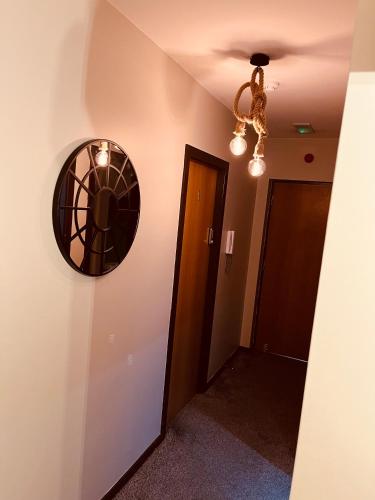 a hallway with a round mirror on the wall at 'Woodbury' at stayBOOM in Lancaster