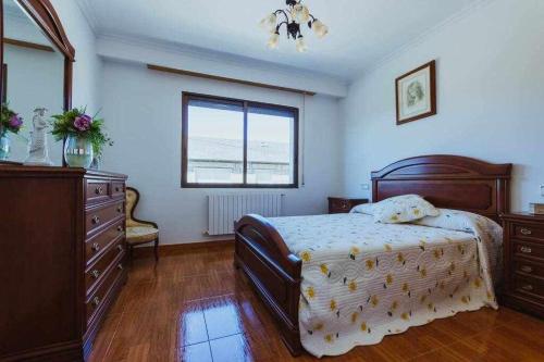 een slaapkamer met een bed, een dressoir en een raam bij Casa Ourense Guxinde in Pereira
