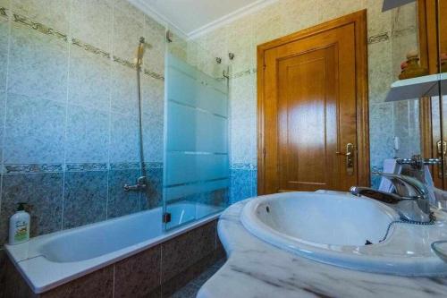 een grote badkamer met een bad en een wastafel bij Casa Ourense Guxinde in Pereira