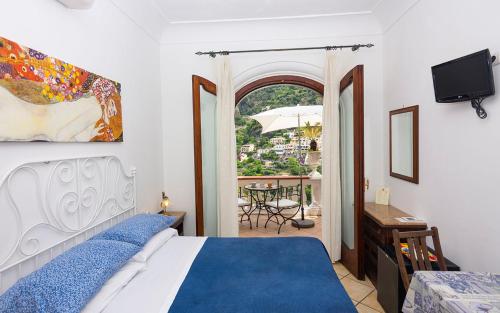 a bedroom with a bed and a view of a patio at Villa Palumbo in Positano
