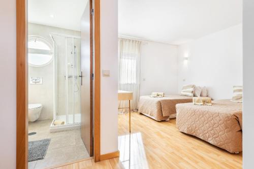 a bedroom with two beds and a bathroom at Casa da Quinta - Private Pool - Faro in Faro