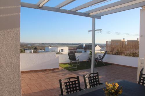 a patio with chairs and a table on a roof at ÁTICO ATALAYA Parking privado gratis in Ayamonte