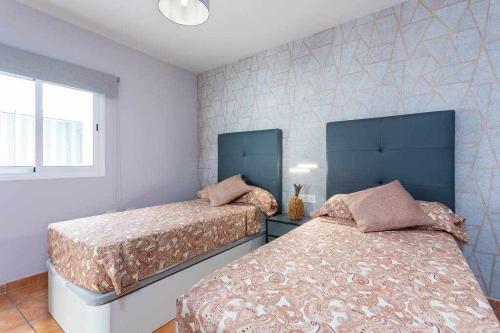 a bedroom with two beds and a window at Sunnyland Teresitas 2 in San Andrés