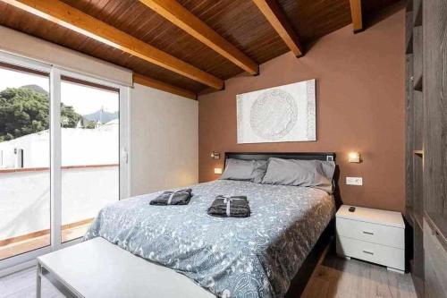 een slaapkamer met een bed met twee schoenen erop bij Sunny island atico las teresitas 4 in San Andrés