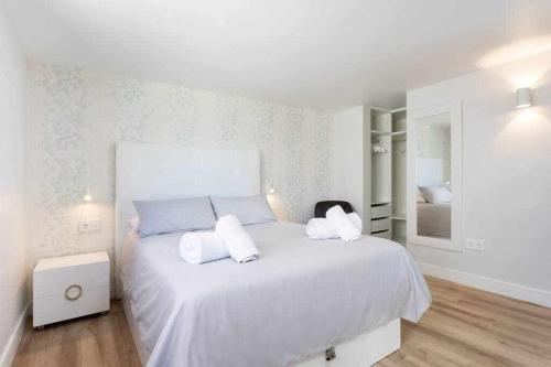 ein weißes Schlafzimmer mit einem großen weißen Bett mit zwei Kissen in der Unterkunft Sunny Island Lago Martianez 5 in Puerto de la Cruz